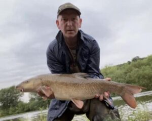 Bank farm Holiday park fisherman catches prize fish on river severn.
