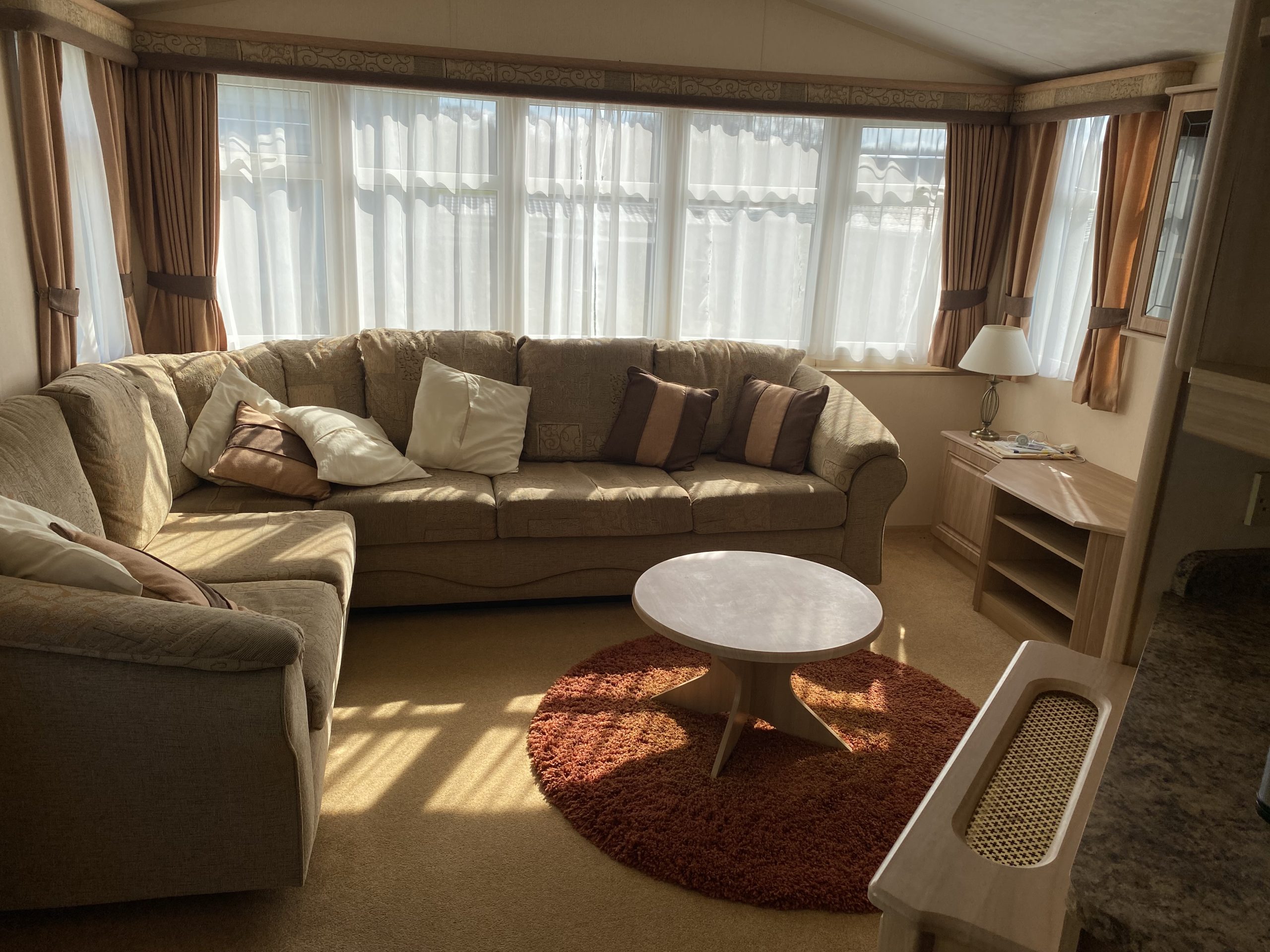 The sofas and round coffee table within a static caravan